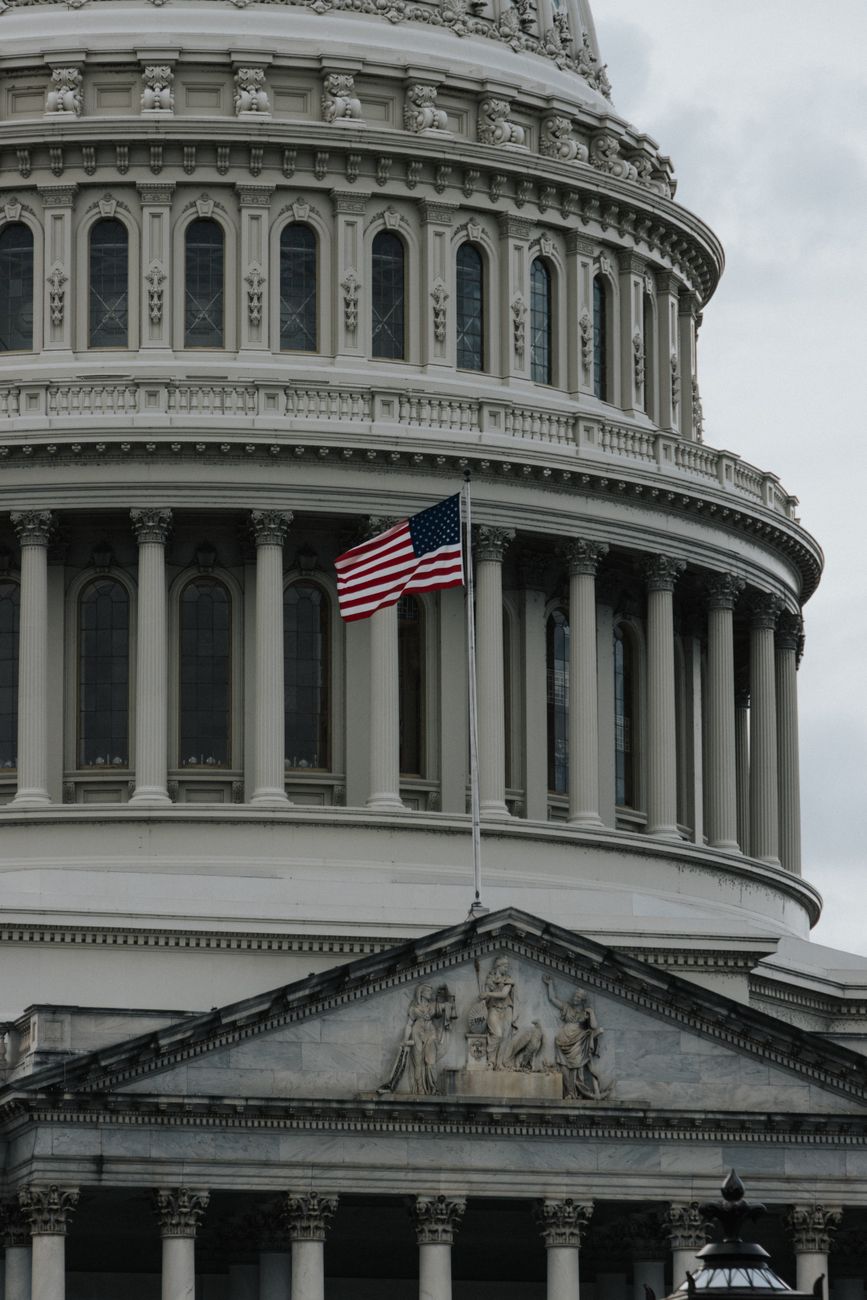 Close up of the United States Capitol with American flag waving outside.