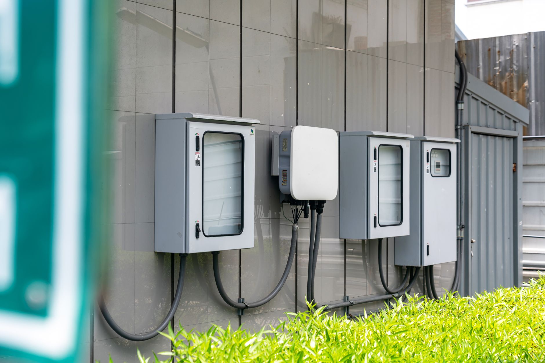 Close up of outdoor electrical utility boxes with cabling on a building exterior.