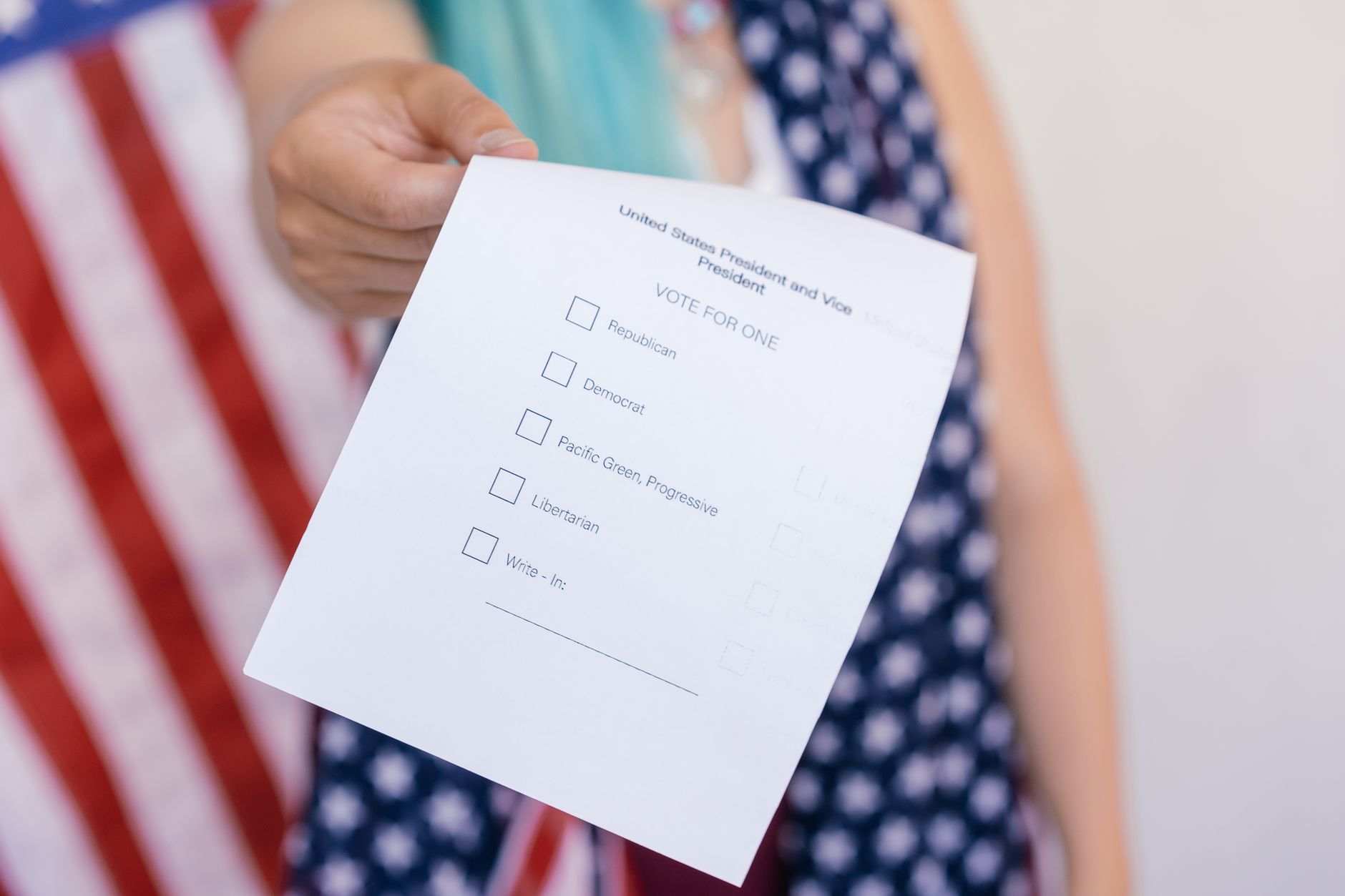 Close up photo of a hand holding a US election voting ballot.