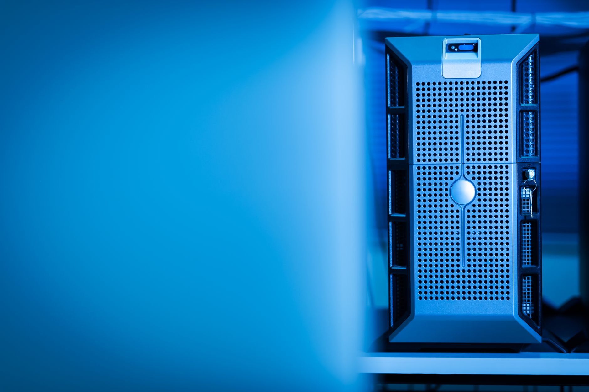 Close up of a modern server unit in a blue lit data center environment.