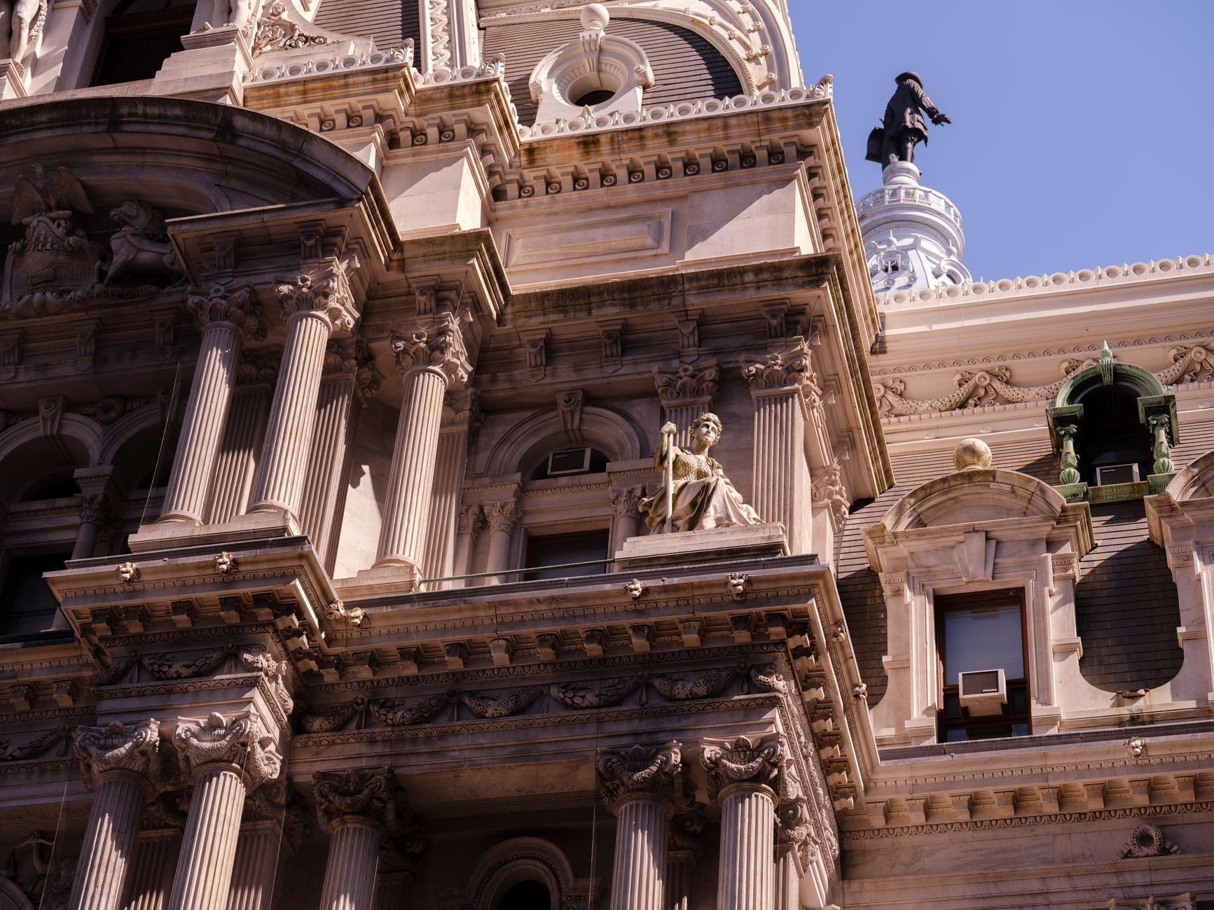 Detailed facade of Philadelphia City Hall showcasing intricate architectural design under a clear blue sky.