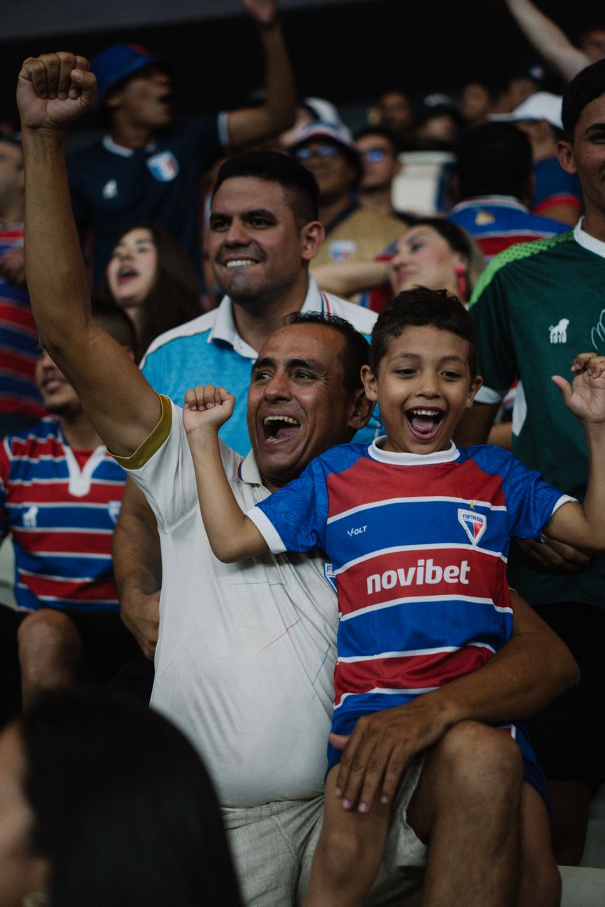 Joyful soccer fans celebrating victory in a crowded stadium, showcasing passion and excitement.