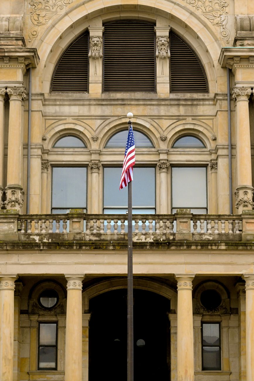 A historic building in Hamilton, Ohio, with a prominently displayed American flag.