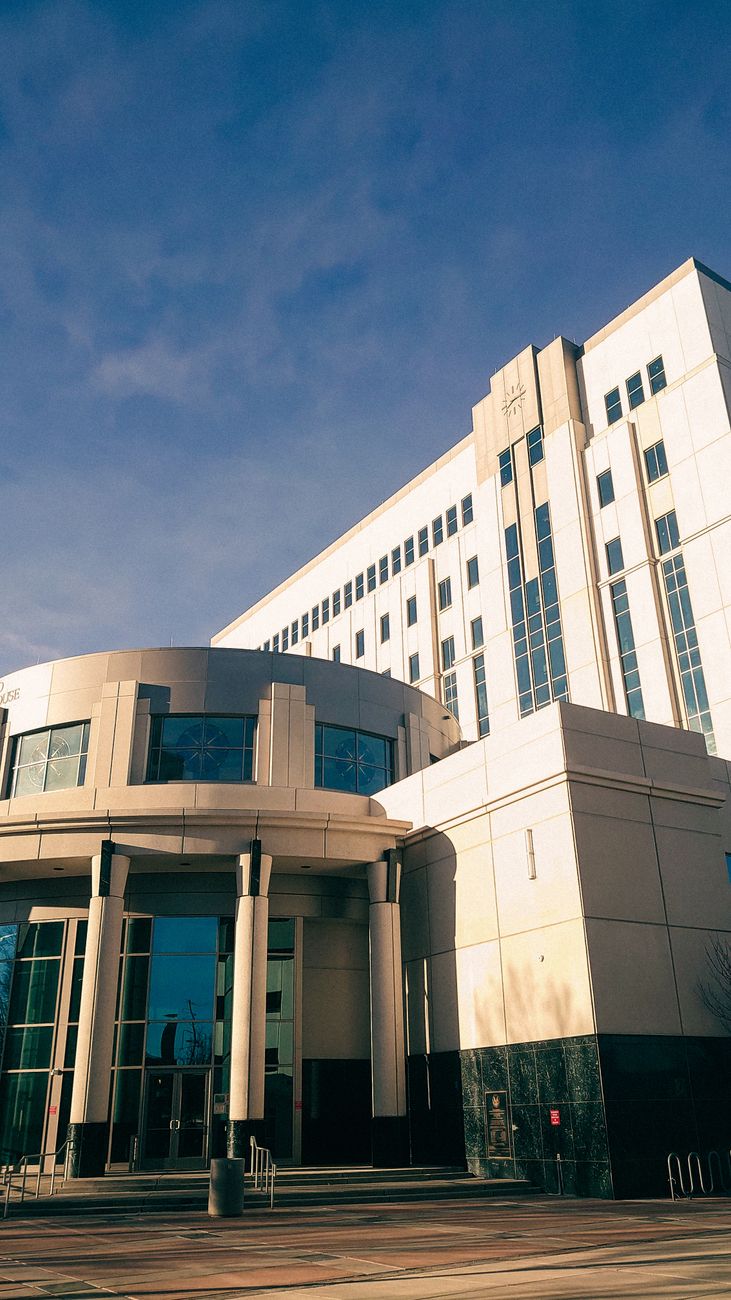 Vertical shot of courthouse in Albuquerque, showcasing modern architecture against clear blue sky.