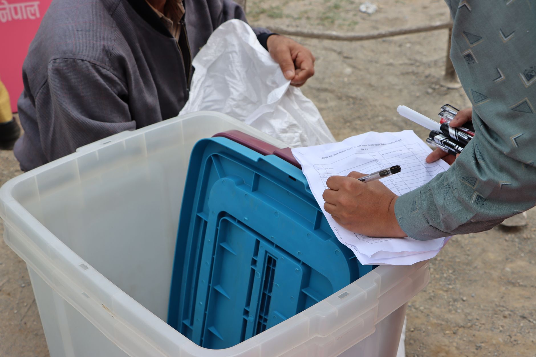 Election authorities managing ballot box during Nepal election.