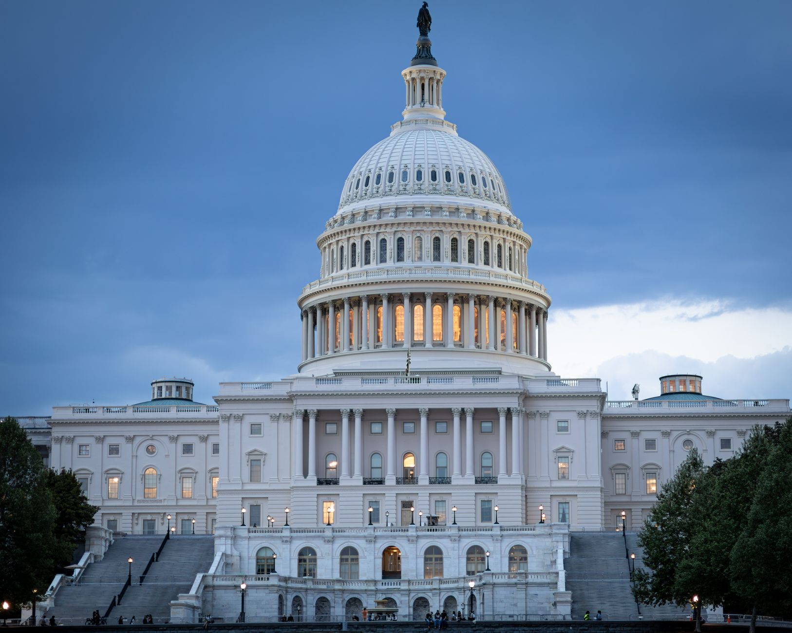 The iconic United States Capitol Building illuminated against a twilight sky.