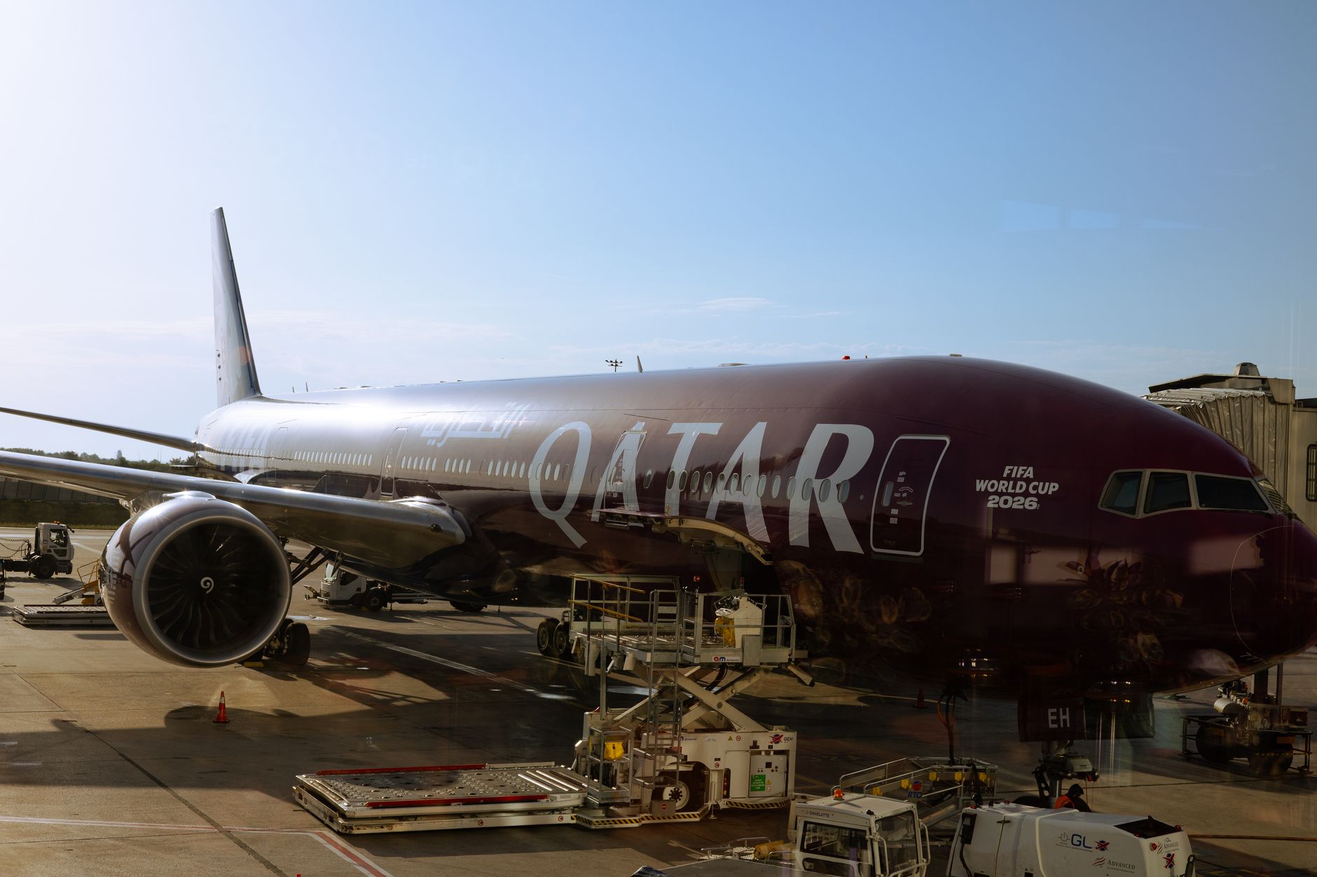 Qatar Airways airplane featuring FIFA World Cup 2026 branding at airport terminal under clear sky.