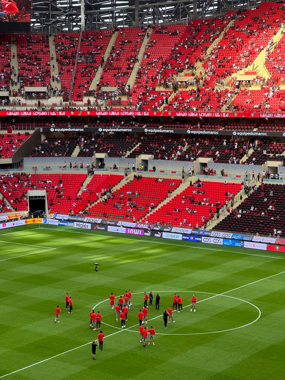 A vibrant football match at Rabat stadium with teams preparing on a bright day.