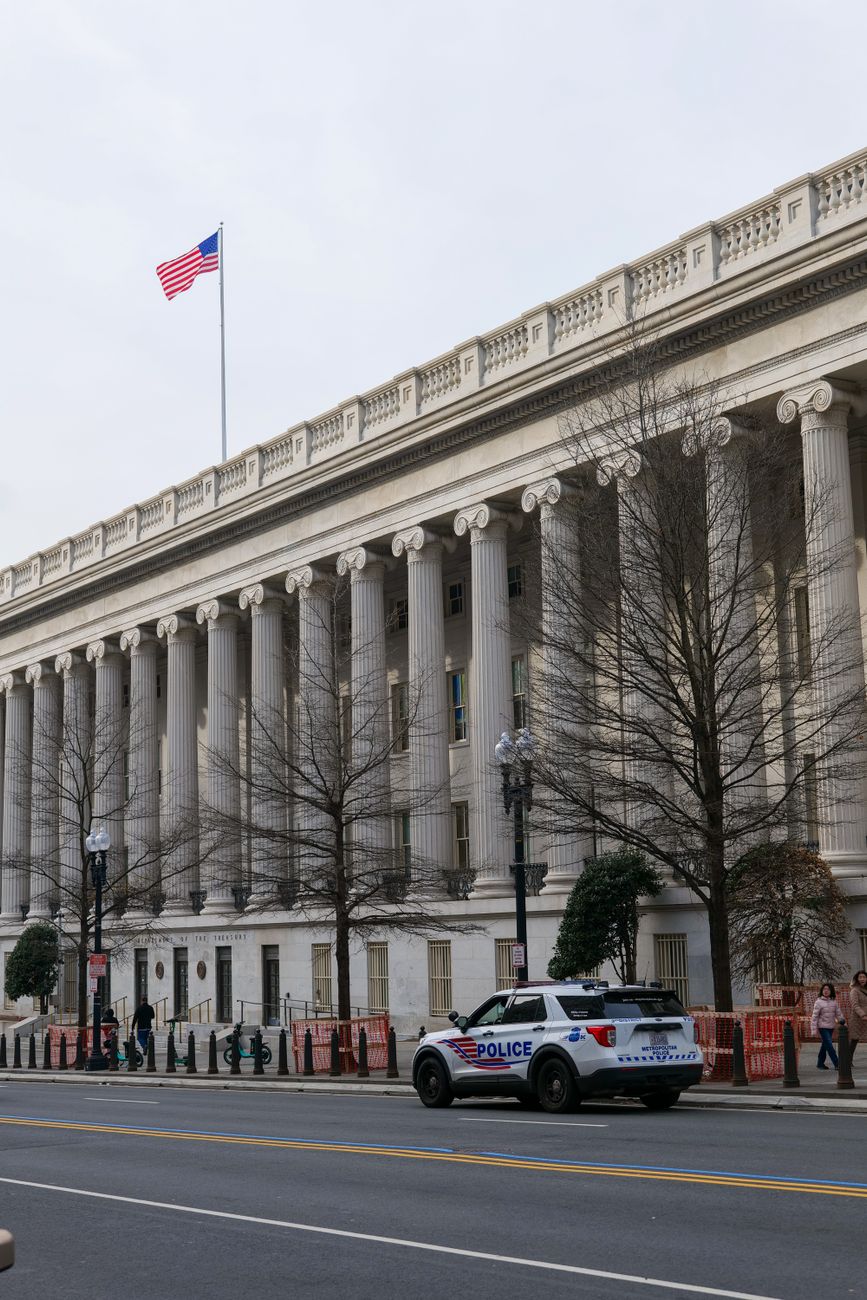 A police car parked in front of a historic building with American flag in Washington D.C.