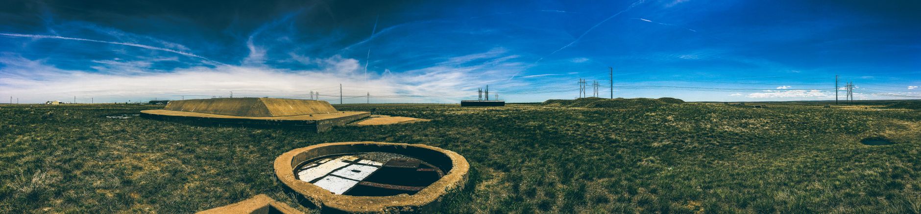 Panoramic view of an abandoned missile silo under a clear blue sky in Deer Trail, Colorado.