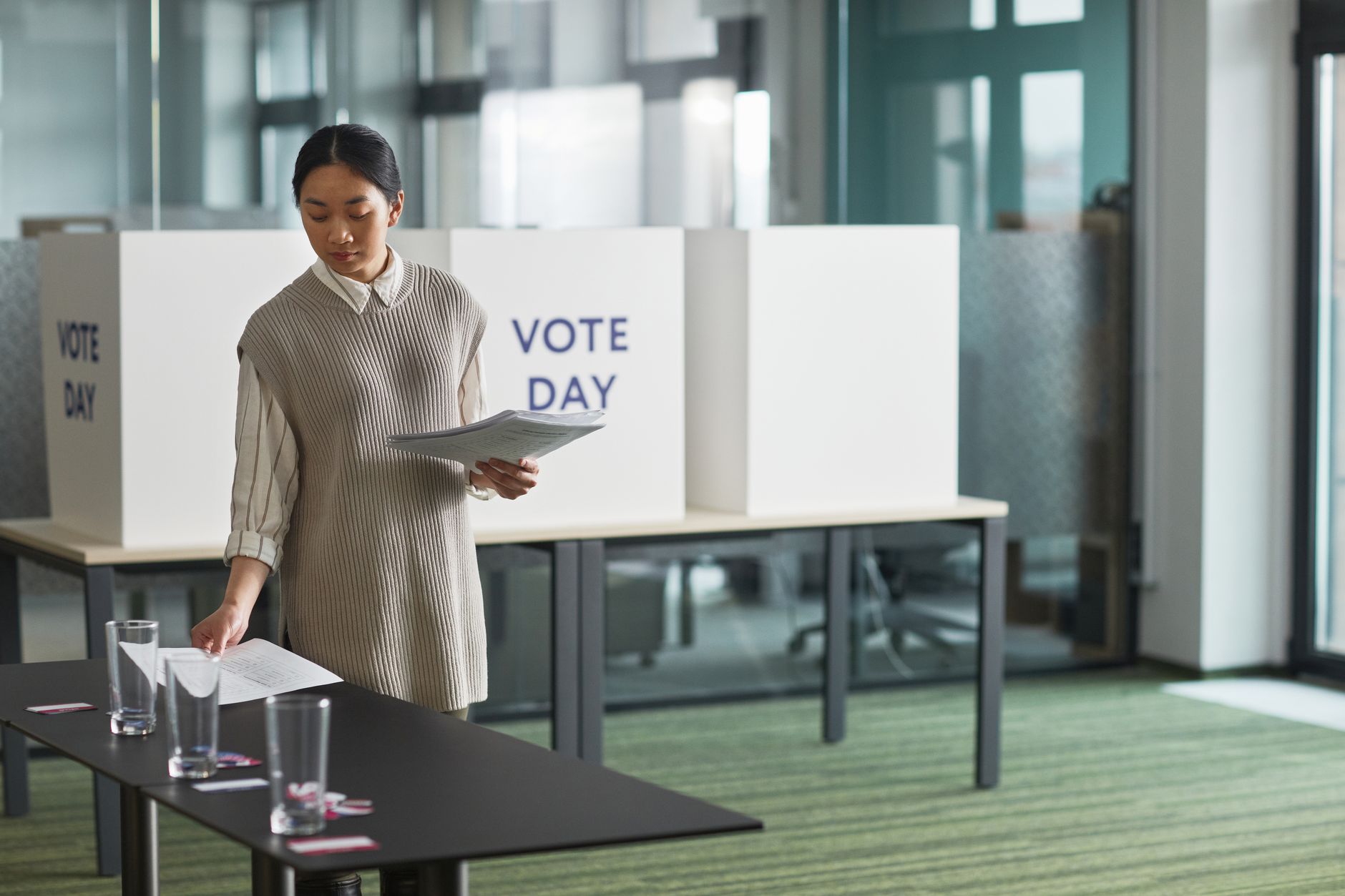 Asian woman preparing voting materials on election day.