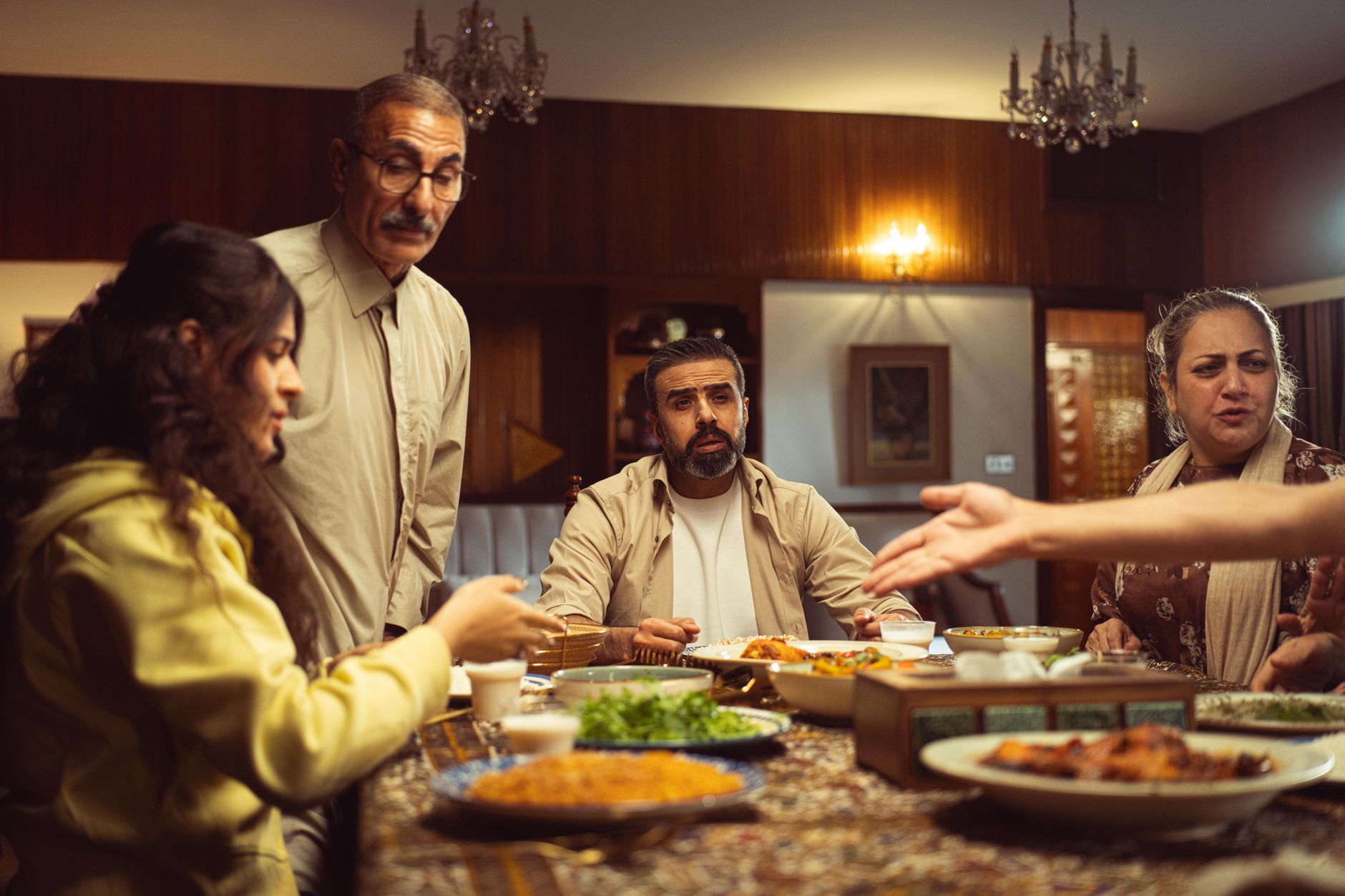 A multi generational family enjoying a meal together in a warm, inviting indoor setting.