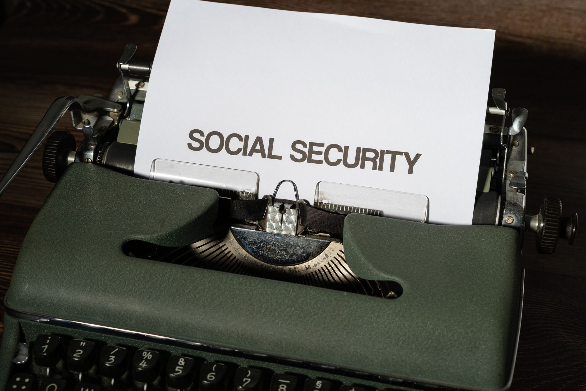 Close up of a vintage typewriter typing 'SOCIAL SECURITY' on paper, classic concept.
