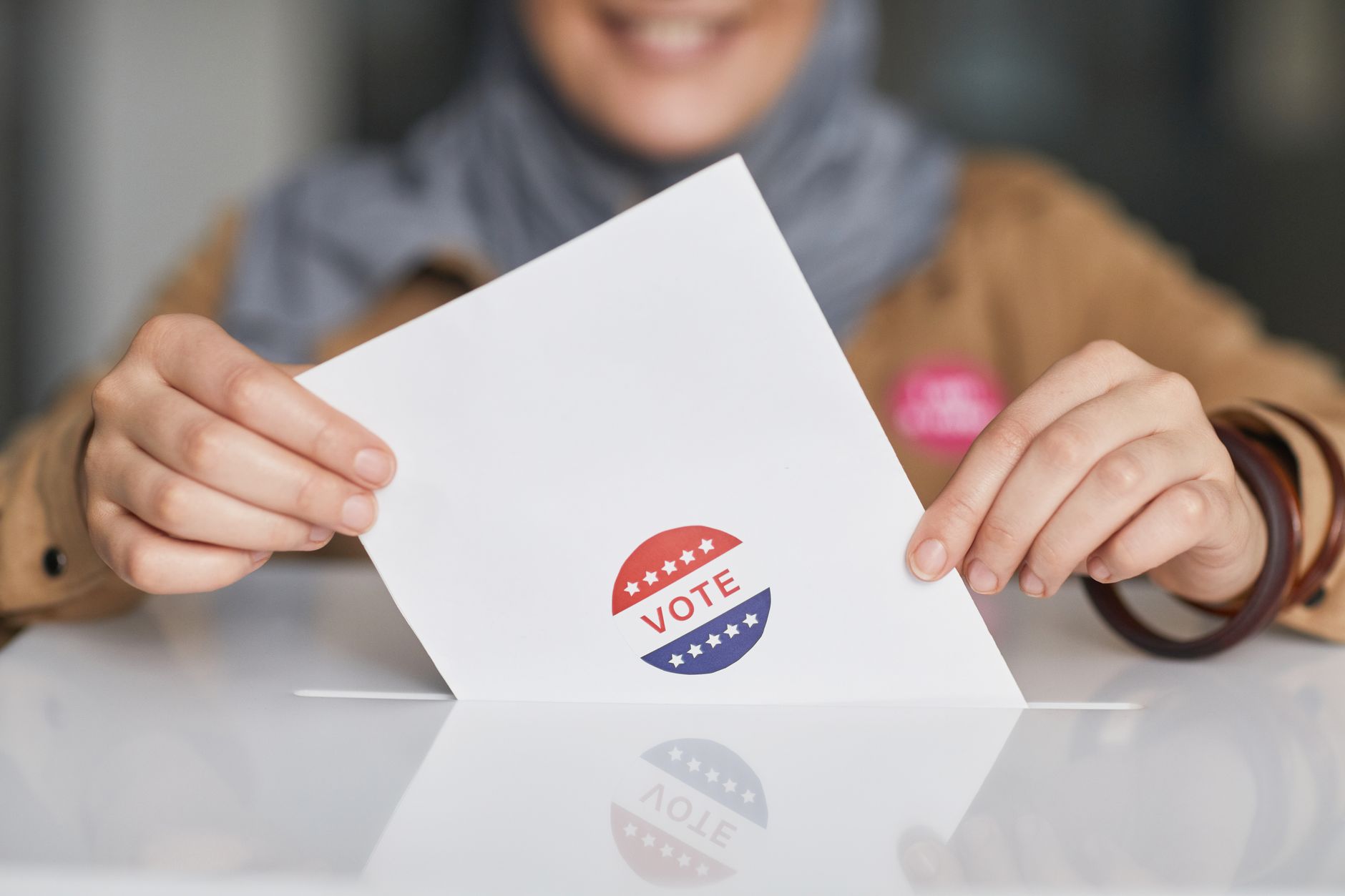 Close up of hands holding a vote ballot, symbolizing election participation.